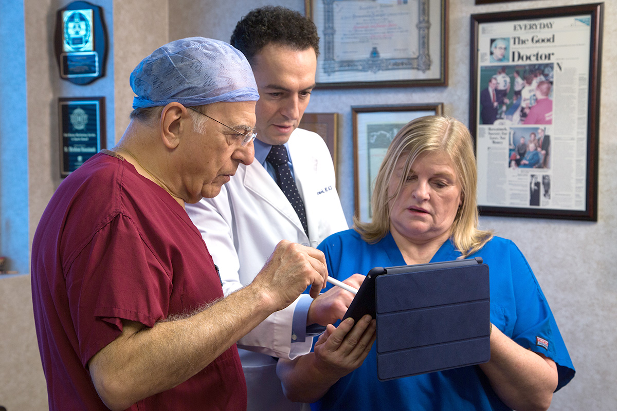 South County Urological doctors looking at tablet with surgery info.